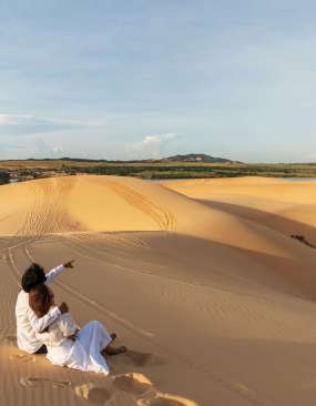 Young couple traveler looking beautiful landscape at white sand dunes in Vietnam, Travel lifestyle concept